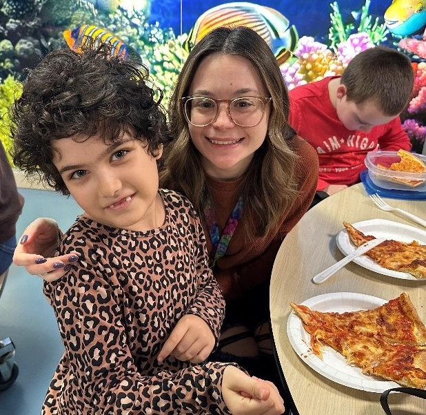 BCCS staff and a student pose for a photo at holiday pizza party