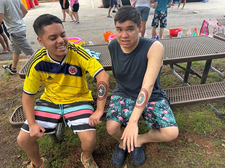 Two students show off the Captain America tattoos they got painted on their arms at the carnival.