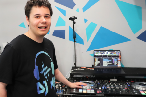 DJ AJ smiles while using the turntable
