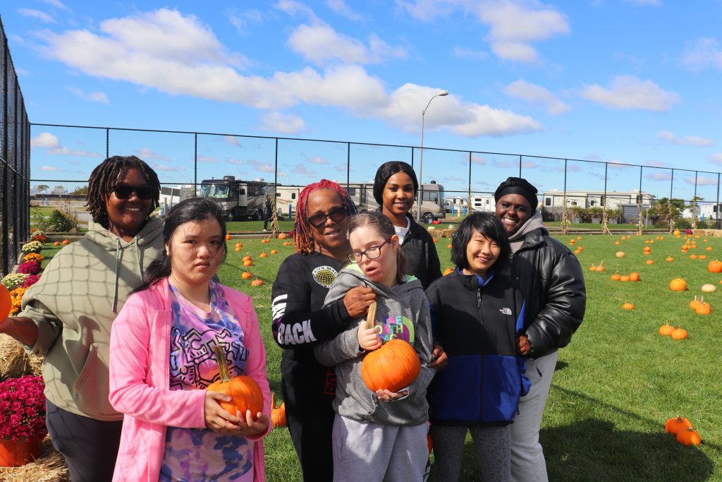 Residents and staff of the Children's Residential Program hold pumpkins that they picked at the Fall Festival