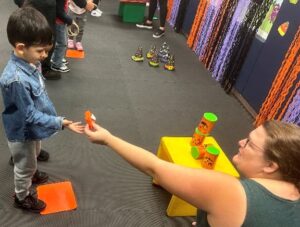 A teacher and student at Marcus Avenue learn with fall themed activities